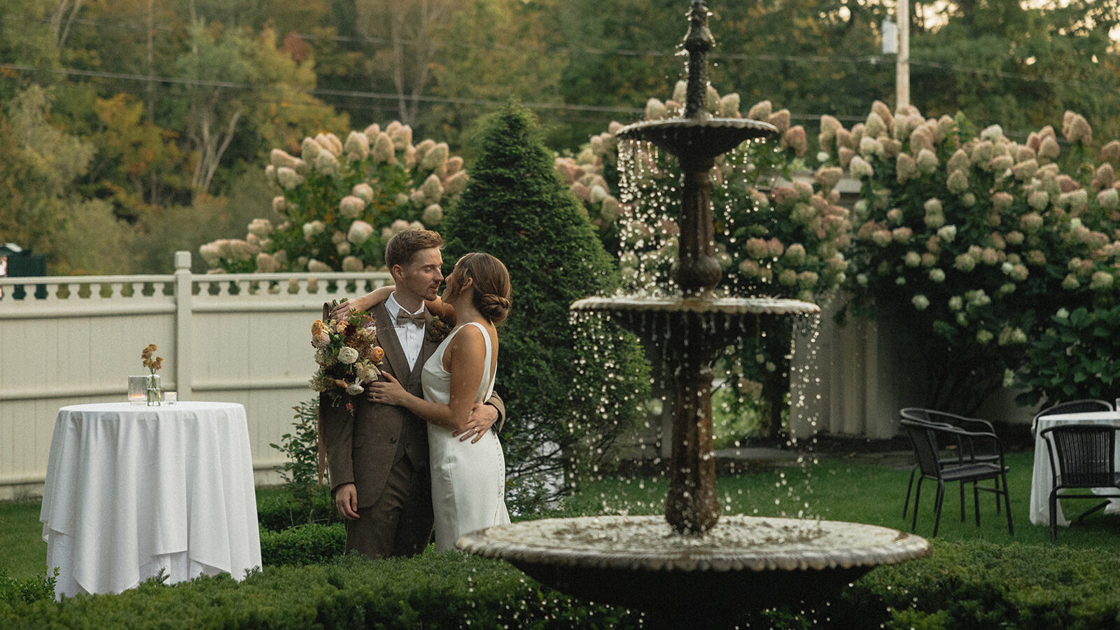 wedding couple's portraits in front of a fountain captured by second photographer